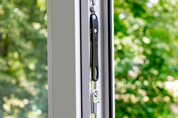 A fragment of a plastic window. Accessories, handle, blinds