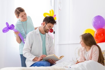 Volunteer in the hospital making sick girl happy