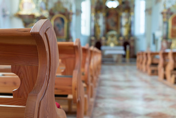 Leere Holzbänke in einer katholischen Kirche