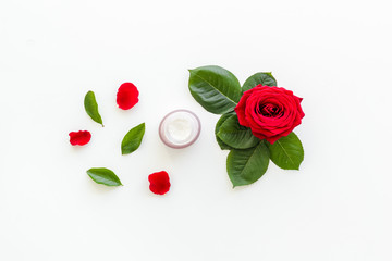Natural floral cosmetics with rose flowers for face and body care on white background top view