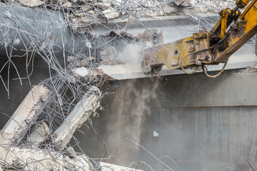 Professional demolition of reinforced concrete structures using industrial hydraulic hammer. Rods...
