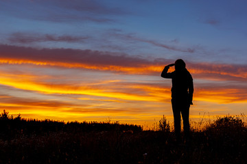 Kobieta patrząca w dal na tle zachodu słóńca