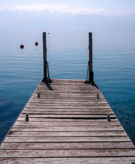 Fototapeta premium Boat Jetty Dock Boardwalk Clear Water Lake with Mountain Backdrop in Lausanne, Switzerland