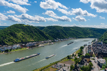 Sankt Goarshausen am Rhein mit Transportschiffen bei Sonnenschein mit wenig Wolken