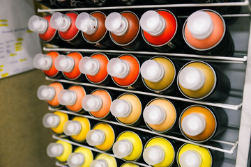 Paint cans are sold in the store. Showcase with metal cans of different colors with paint for drawing. The concept of graffiti and creativity
