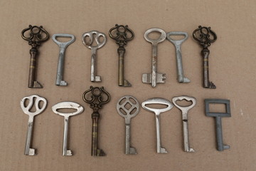 Mettalic vintage keys on the brown background, figures from keys