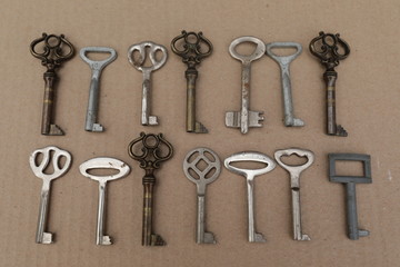 Mettalic vintage keys on the brown background, figures from keys
