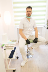 Hijama therapist sitting on the chair and posing at the massage room.