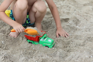 Fototapeta na wymiar child playing with toys on the beach