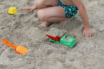 child playing with toys on the beach