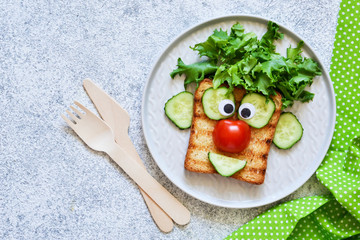 Cheerful clown. Sandwich for children for breakfast. View from above.
