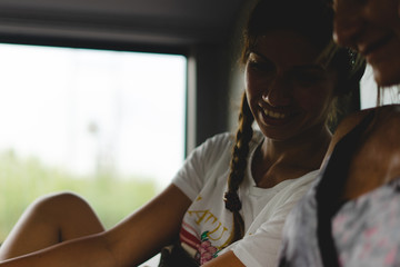 Young woman sitting in a bus public transportation smiling in shadow