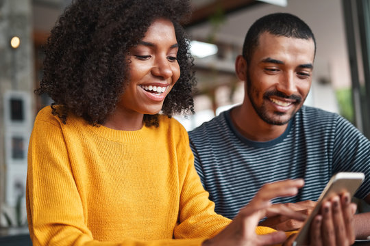 Cheerful young couple looking at smartphone