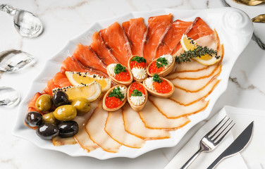 Seafood platter with salmon slice, pangasius fish, red caviar, shrimp, decorated with olives and...