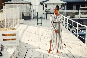 Black girl. Woman in a white dress. Lady on the pier