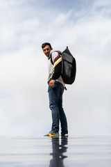 Young And Slim Man Observing From Above With Sky Background, Dressed In Casual Clothes