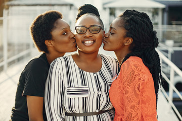 Three black girls. Women in a summer park. Friends have fun