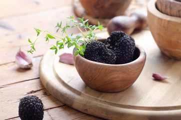 Black truffle in wooden bowl for summer truffles sauce.