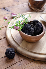 Black truffle in wooden bowl for summer truffles sauce.