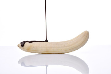 temptation concept - banana with chocolate on a white