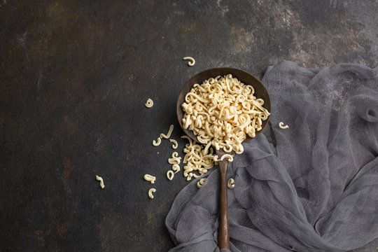 Homemade Small Macaroni in Old Ladel on Black Background