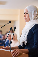 Young pretty confident muslim female delegate in hijab