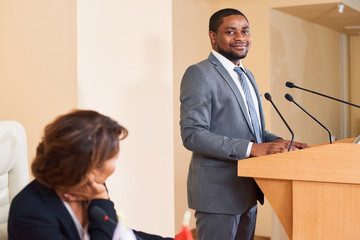 Happy young successful speaker in elegant suit