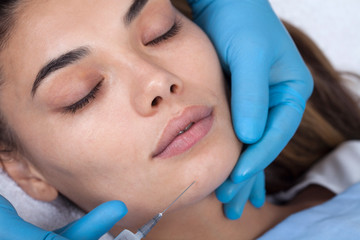 Young woman undergoing procedure of bb glow treatment in beauty salon