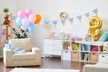Interior of living-room in modern flat prepared for birthday party