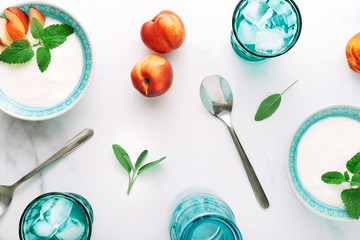 Top view of healthy breakfast of natural greek yoghurt, nectarines and water on marble table. Flat lay.