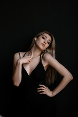 Fototapeta na wymiar Beautiful slim young woman posing on a black background. Emotions