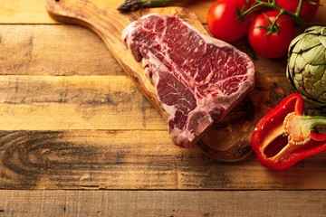 Juicy fresh piece of marbled beef steak with vegetables for grilling. Culinary background, recipe book, delicious food, Steak cooking. With space, horizontal photo