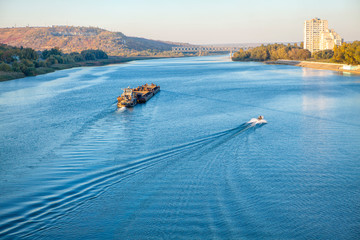 Obraz premium cargo ship and motorboat on the river