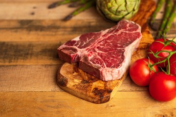 Juicy fresh piece of marbled beef steak with vegetables for grilling. Culinary background, recipe book, delicious food, Steak cooking. With space, horizontal photo