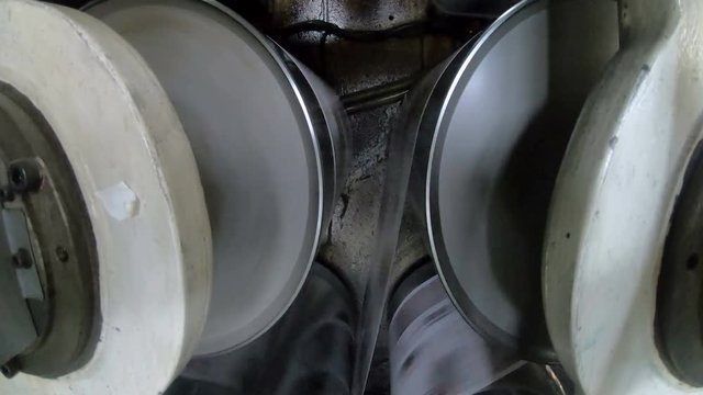 A large webset offset printing press running a long roll off paper over its rollers at high speed