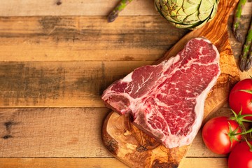 Juicy fresh piece of marbled beef steak with vegetables for grilling. Culinary background, recipe book, delicious food, Steak cooking. With space, horizontal photo