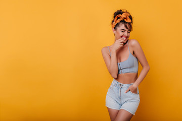 Pretty slim caucasian lady smiling on orange background. Laughing ecstatic girl having fun on...