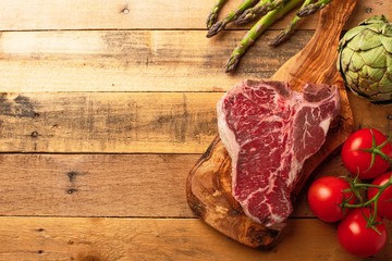 Juicy fresh piece of marbled beef steak with vegetables for grilling. Culinary background, recipe book, delicious food, Cooking steak. With space. Flat lay