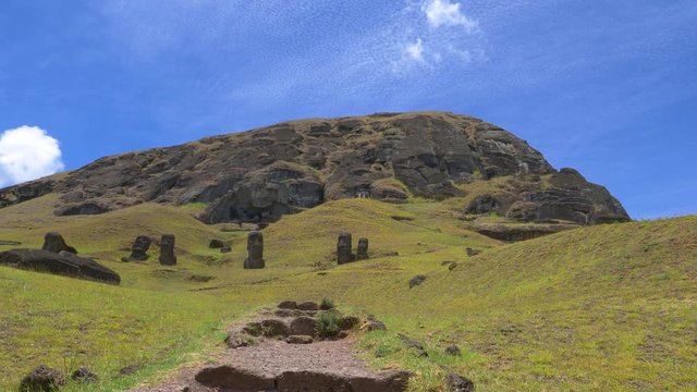 DRONE: Mysterious moai statues face empty trail leading up to the volcano on Easter Island. Breathtaking drone view of the volcanic landscape and ancient sculptures on remote exotic island in Chile.