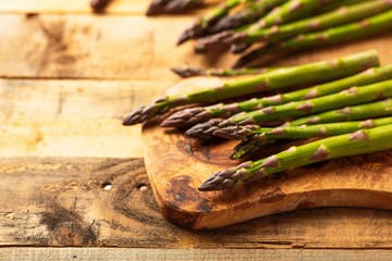 Asparagus on a cutting board. On wooden background. Culinary background. Diet. Delicious and healthy food.