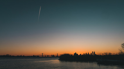 Sunset over philadelphia skyline with airplane streat