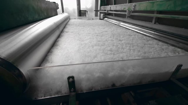 Non-woven material is getting processed by the press