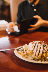 Man eating fried ice cream and paying bill at mexican restaurant