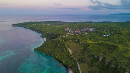 Beautiful aerial view of village beside blue ocean with nice sunset sky