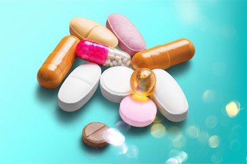 Colorful Pills, Capsules and Tablets on blue desk