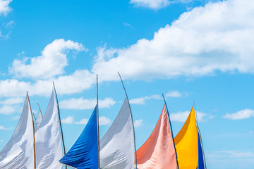 Colorful view of the tops of sailing boats in a beautiful blue sky day on the beach