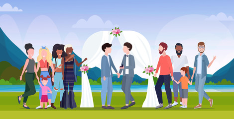 Fototapeta premium couple newly weds gays standing behind floral arch same gender happy married homosexual family wedding celebrating concept landscape background full length flat horizontal