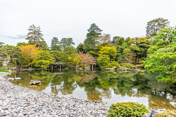 Kyoto, Japan wide angle view of green spring garden in Imperial Palace architecture with water reflection and stones, bridge on lake pond