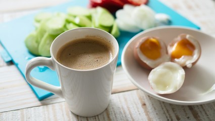 Boiled eggs with fresh cucumber salad and coffee cup breakfast set - top view breakfast food concept