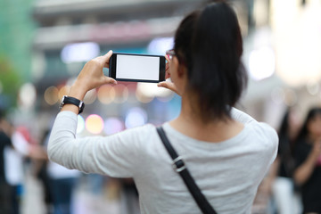Woman with smartphone take pictures in modern city
